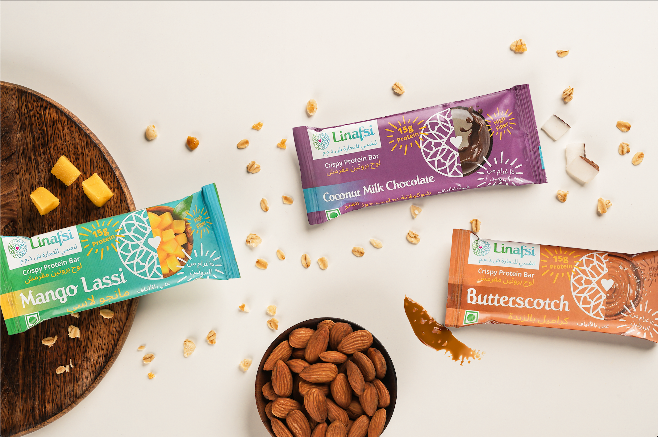 Linafsi - crispy protein bars -Lifestyle Image of Coconut Milk Chocolate, Mango Lassi and Butterscotch protein bars- ingredients almonds, oats, coconut, mango pieces shown