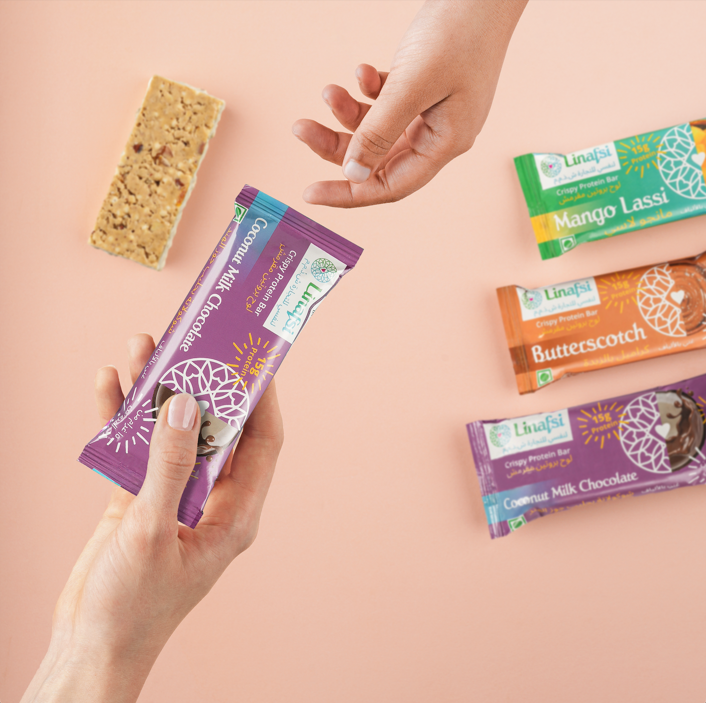 Linafsi - crispy protein bars - Image of hand reaching to share coconut milk chocolate bar with a friend, pink background