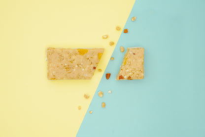 Mango lassi protein bar cut on a two-colored background, showcasing its texture. A delicious and nutritious snack for fitness enthusiasts.